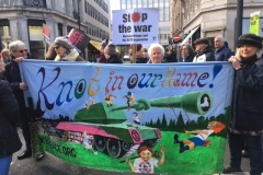 Angie-with-Knot-in-our-Name-banner-25Feb23-at-Stop-the-War-demo-in-London
