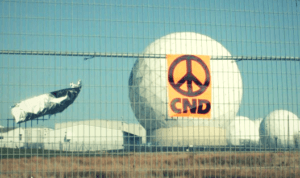 CND sticker on fence around RAF Menwith Hill. Image lines up to be in the middle of a radome at the base