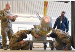 Four people stand around a damaged B61 nuclear bomb.